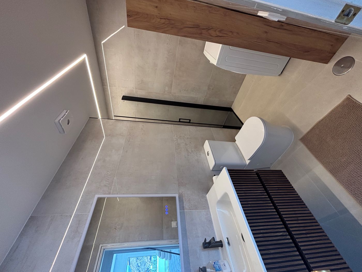 Modern bathroom with walk-in shower and washing machine
