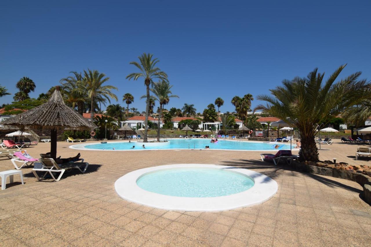 Pool terrace with sun loungers, parasols and a separate children's pool
